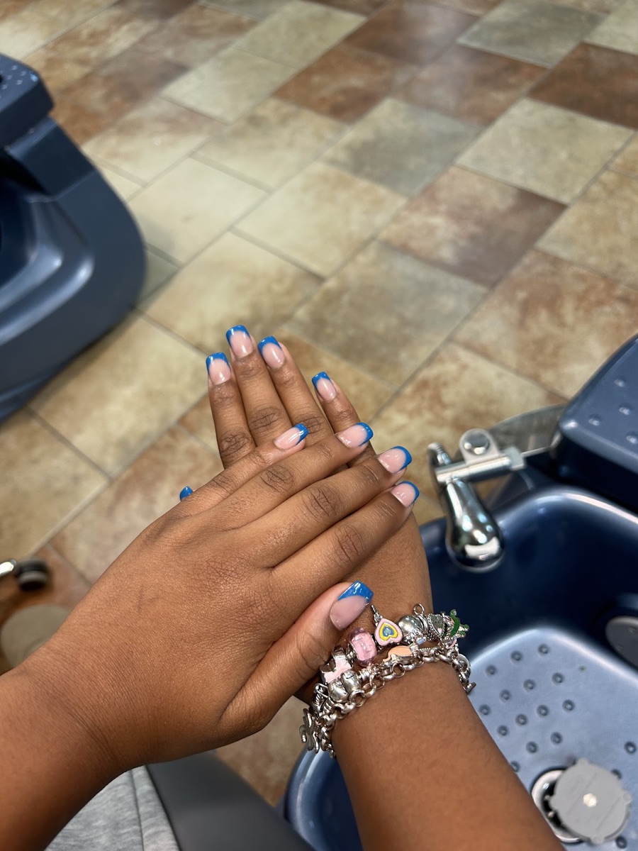 Blue French-tip nails styled at the salon