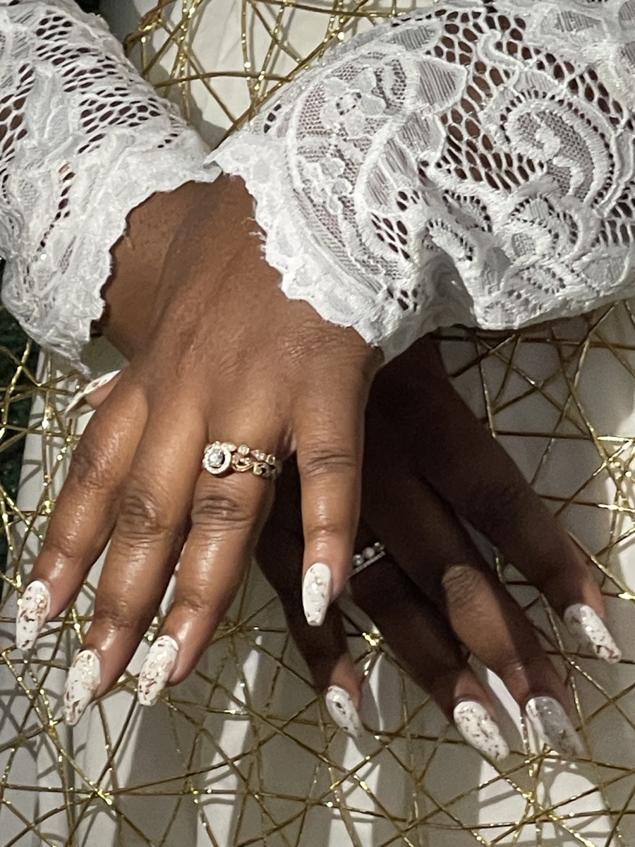 Elegant white marbled stiletto nail art with gold accents at Christian Nails in Stockbridge, GA